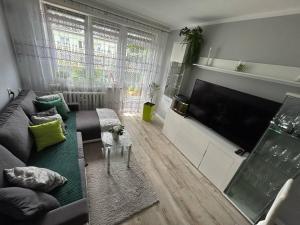 a living room with a couch and a large flat screen tv at BM Apartament in Augustów