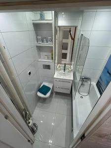 a white bathroom with a sink and a mirror at BM Apartament in Augustów +15 photos