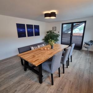 a wooden dining room table with chairs and a potted plant at Pfalztraum Fewo's in Bruchweiler-Bärenbach +28 photos
