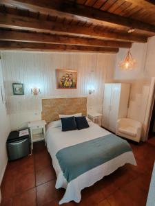 a bedroom with a large bed and a chair at Alojamientos el Paramo in San Vicente de la Barquera