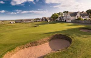 a golf course with a hole in the middle of a green at The Hillside Hotel & Restaurant in Hillside