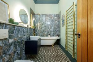 a bathroom with a tub and a sink at The Royal Mint apartment at The Bank of England in Bristol