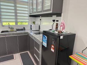 a kitchen with a black refrigerator and a microwave at e-Staycation in Kuala Terengganu