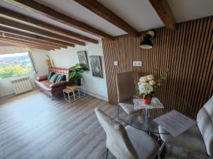 a living room with a glass table and a couch at Alojamientos el Paramo in San Vicente de la Barquera