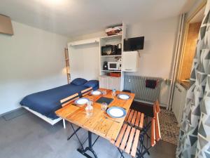 a living room with a table and a couch at La Pause Bourboulienne Appartement RDC avec balcon in La Bourboule