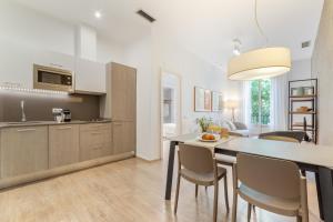 a kitchen and dining room with a table and chairs at Aspasios Rambla Catalunya Apartments in Barcelona