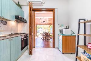 cocina con puerta que da a un patio con mesa en Grace's House, en Villasimius 38 fotos más