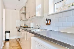 a white kitchen with a sink and a counter at Number 5 in Margate +11 photos