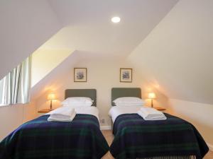 - 2 lits dans une chambre mansardée dans l'établissement North Cottage, à Glenelg