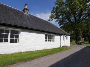 - un bâtiment blanc avec deux fenêtres et un arbre dans l'établissement North Cottage, à Glenelg