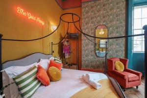 a bedroom with a bed and a red chair at The Gold Penny studio apartment at The Bank of England in Bristol
