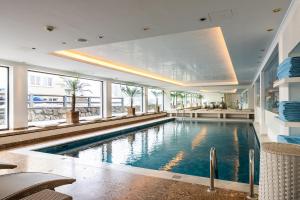 a large swimming pool in a building with windows at Thurnhers Residences Serviced Apartments in Lech am Arlberg