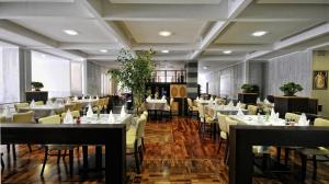 a dining room with white tables and chairs at Harmonia Apart Hotel in Boreti