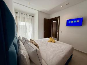 a yellow teddy bear sitting on top of a bed at Chic & Bright Apartment in Kenitra