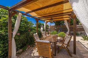 drewniana pergola z drewnianym stołem i krzesłami w obiekcie Holiday house Depope w mieście Skrbčići +27 zdjęć