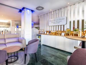 a restaurant with a couch and tables and chairs at Hotel Ocean House Costa del Sol, Affiliated by Meliá in Torremolinos