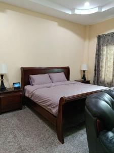 ein Schlafzimmer mit einem Bett und einem Ledersofa in der Unterkunft Diamond Villas in Ban Phang Phrao