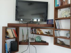 a flat screen tv sitting on top of a book shelf at Ellie's House in Vári