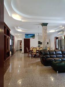 ein Wohnzimmer mit einem Ledersofa und einem Esszimmer in der Unterkunft Diamond Villas in Ban Phang Phrao