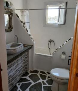 a bathroom with a sink and a toilet and a tub at Ellie's House in Vári +14 photos