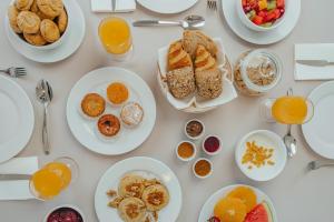 a white table with plates of breakfast food on it at Serpa Hotel in Serpa