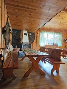 a dining room with a wooden table and benches at U Młynarczyków in Dębno