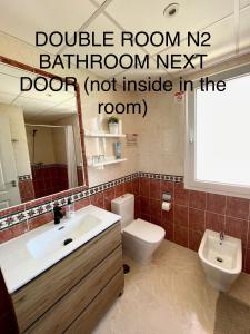 a bathroom with a sink and a toilet and a mirror at Marbella Deluxe Rooms in Royal Cabopino Townhouse in Marbella