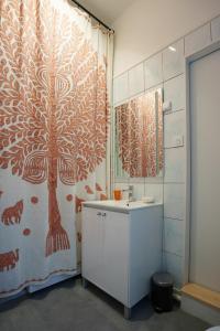 a bathroom with a shower curtain and a white sink at Duplex 8 pers 103m2 #MaisonSavaron in Clermont-Ferrand