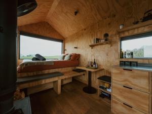 a bedroom in a tiny house with a bed and a desk at Polaris in Kelsall