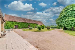 a stone barn with a roof covered in ivy at Le Clos de Villecourt - Piscine Privée in Gueugnon