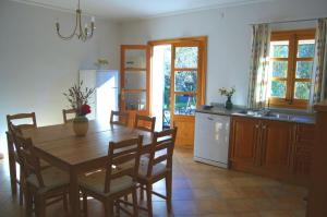 a kitchen with a wooden table and a dining room at Ca'n Nadal Casa rural con piscina in Alaró