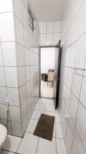 Un baño con una puerta que da a una habitación con una silla. en Suíte Privativa Central próximo a unip, São Leopoldo Mandic,Shopping iguatemi, en Campinas
