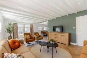 a living room with a couch and a tv at Duin & Daal in Helvoirt