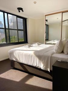 a bedroom with two beds and a large window at Elegant Hyde Park View Retreat With Gym & Rooftop Pool in Sydney