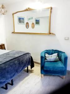 una camera con una sedia blu e uno specchio di Casa vacanza LA MIA CASETTA SUTRI a Sutri