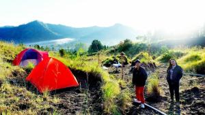 a group of people standing next to a tent on a hill at Batur Sunrise Camp in Kintamani +7 photos