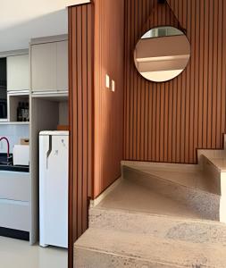 a kitchen with a white refrigerator and a mirror at Casa linda com piscina e Bem Próximo ao Parque in São Lídio