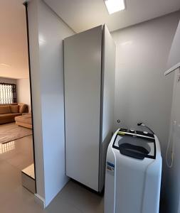 a room with a refrigerator and a living room at Casa linda com piscina e Bem Próximo ao Parque in São Lídio