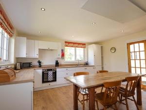 une grande cuisine avec une table et des chaises en bois dans l'établissement North Cottage, à Glenelg