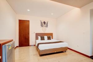 a bedroom with a bed in a white room at Collection O near MRT Cipete Raya formerly Terogong Sembilan in Jakarta