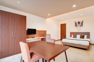 a bedroom with a bed and a wooden table in a room at Collection O near MRT Cipete Raya formerly Terogong Sembilan in Jakarta