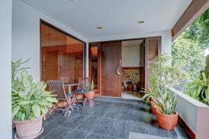 an indoor patio with plants and a table and chairs at Collection O near MRT Cipete Raya formerly Terogong Sembilan in Jakarta