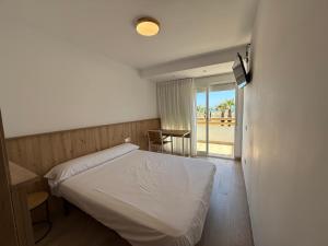 A bed or beds in a room at Pensión La Ola