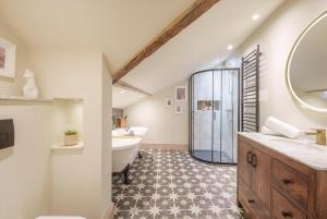 a bathroom with a large mirror and a tub and a sink at Tellers secret loft apartment The Bank of England in Bristol