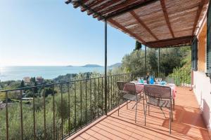 eine Terrasse mit Tisch und Stühlen auf einem Balkon in der Unterkunft "Ulivi House" inside a Private Park, shared Pool, Tennis, 2 AC BDR, 2BTH, parking next home and private garage in Lerici! in Lerici