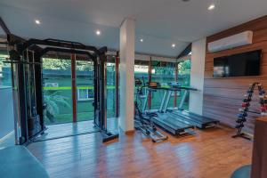 a gym with a treadmill and a flat screen tv at Hotel Laghetto Viale in Gramado +32 photos