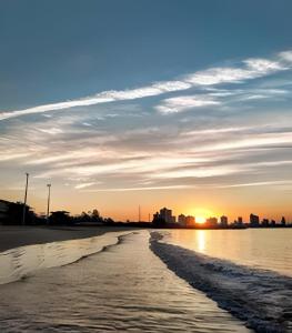 Casa na Cidade do Beto Carrero e a 50m da Praia في بنها: شاطئ مع غروب الشمس في الخلفية