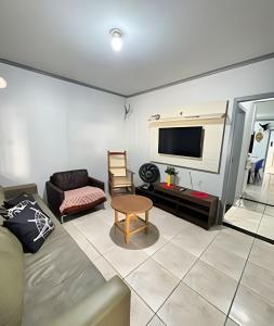 Casa na Cidade do Beto Carrero e a 50m da Praia في بنها: غرفة معيشة مع أريكة وتلفزيون