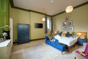 a bedroom with a bed and a blue couch at The Royal Mint apartment at The Bank of England in Bristol