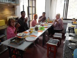 a group of people sitting at a table eating food at Touri House in Kathmandu